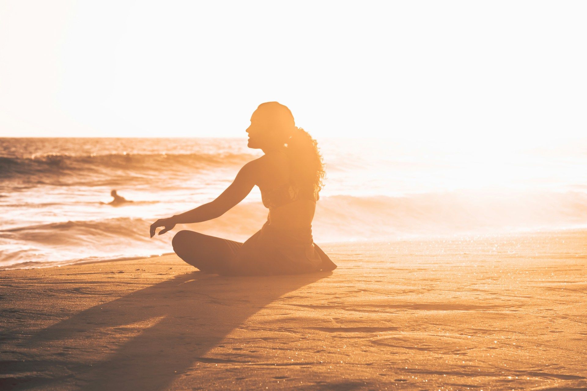 woman meditating at sunset